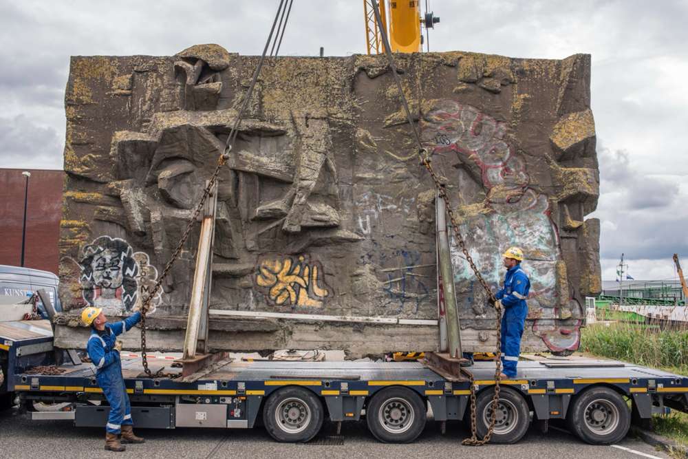 Het betonreliëf van Pierre van Soest wordt in 2019 met een kraan op een dieplader gezet voor de reis naar de Binckhorst
