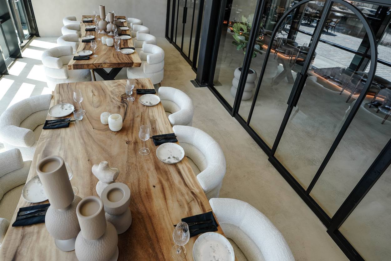 Twee tafels in de private room naast de stalen pui