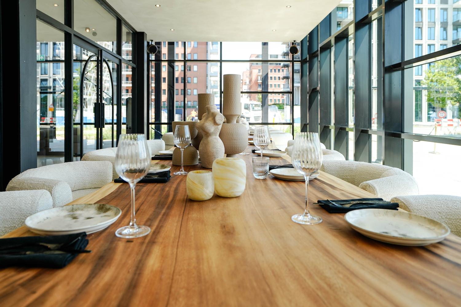 De lange tafel in de private room, gedekt voor een diner